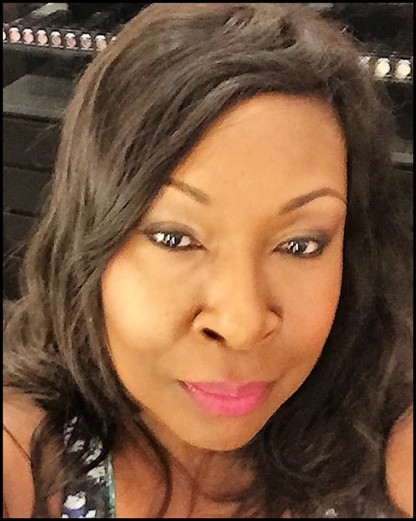 Close-up of a woman with wavy hair and pink lipstick.