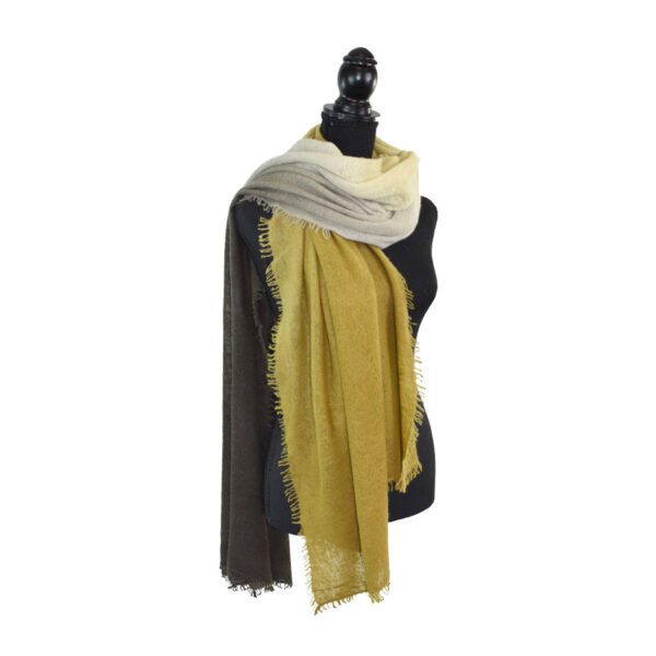 Mannequin draped in layered scarves of black, white, and mustard yellow.