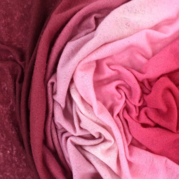 Folded fabric in shades of pink and red arranged in a swirl.