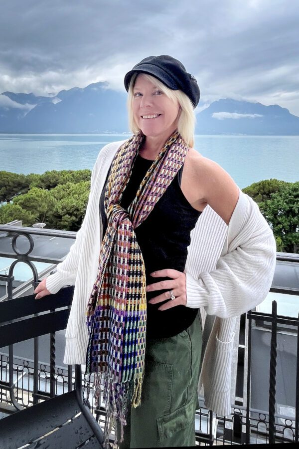 Woman in cardigan and scarf, scenic view.