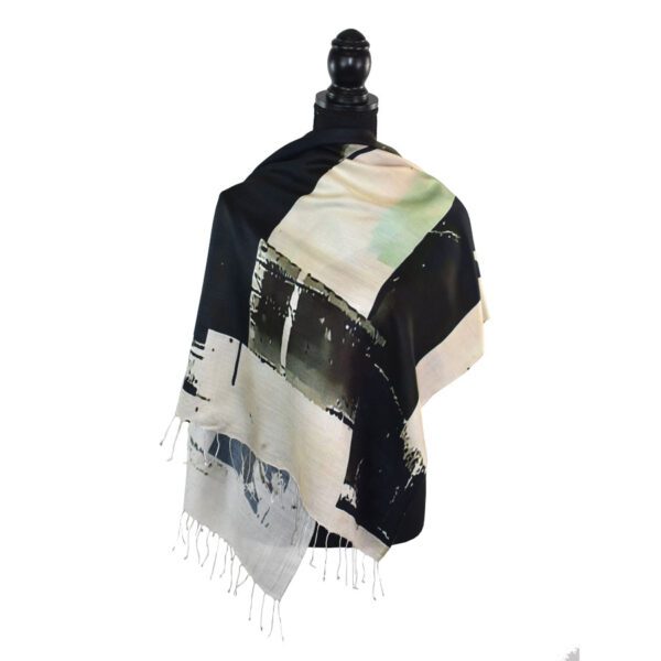 Black and white fringed shawl draped on a stand.