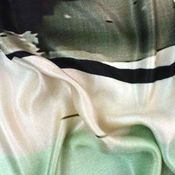 Close-up of silky, shiny fabric with gradient shades of green and cream.
